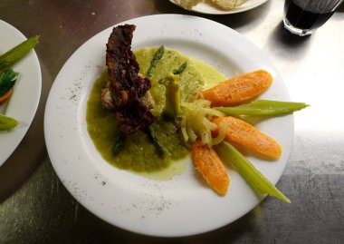 Kızarmış pastırma ve kuşkonmaz kremalı domuz filetosu. Tereyağında kurutulmuş havuç, soğan ve kereviz..