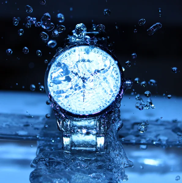 Reloj bajo gotas de agua — Foto de Stock