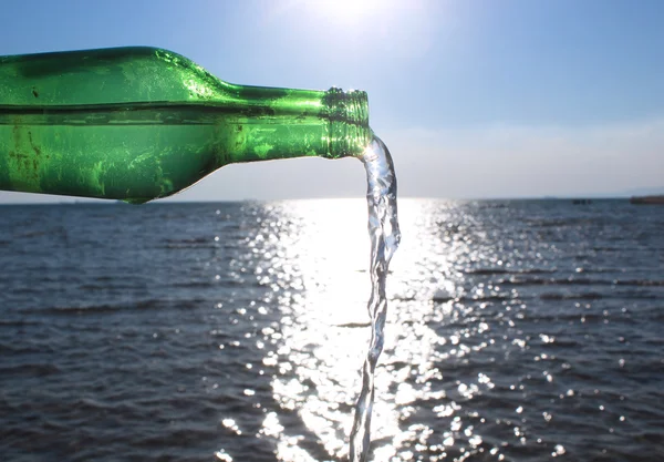 Water gieten van glazen fles in water — Stockfoto
