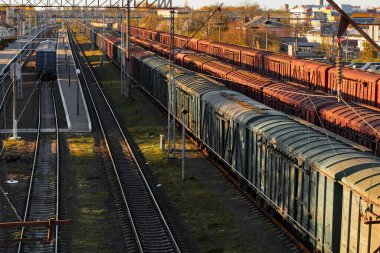 Lutsk, Ukrayna - 26 Mayıs 2021: Raylı yük vagonlu lokomotif. Tren istasyonunda yük vagonları var. Sınıflandırma ya da demiryolu tersanesi. Deposunda nakliye konteynırı olan kargo trenlerinin çatıları.