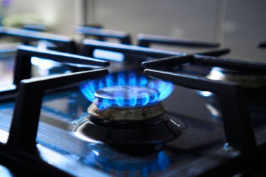 Gaz hob mavi alev üretir sera gazı emisyonları. Mutfak ocağı ocağı, yanıcı gaz, sengaz, propan ve bütan gazıyla çalışan bir ocağın üstünde. Isıtıcı olarak fırın. Doğal kaynakların israfı