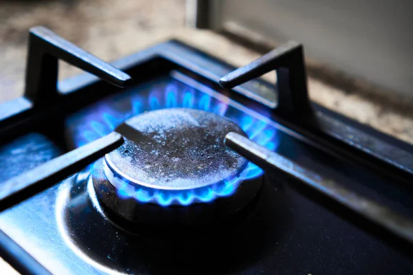 Isıtıcı olarak fırın. Gaz hob mavi alev üretir sera gazı emisyonları. Doğal kaynakların israfı. Mutfak ocağı ocağı, yanıcı gaz, sengaz, propan, bütan gazıyla çalışan bir ocağın üstünde..