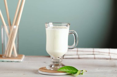 Kefir, mayalanmış süt içeceği veya beyaz ahşap arka planda bir bardakta yoğurt..