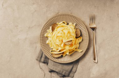Tagliatelle İtalyan makarnası. Arka planda taze siyah trüf mantarı var..
