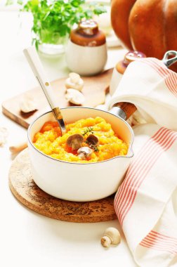 Beyaz kasede mantarla ezilmiş balkabağı püresi..