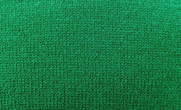 Green sweater knitted texture background, close up, top view, copy space.