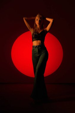 Sinema tarzında poz veren güzel bir kız. Genç bir sarışın ve renkli bir ışıkla fotoşop..