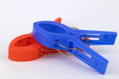 Beyaz üzerine kırmızı ve mavi mandallar.