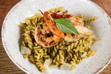 Fusilli pasta spicy with grilled shrimps in a ceramic plate. Fusion food style