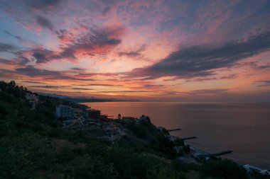 Denizin üzerinde renkli bulutlu gün doğumu