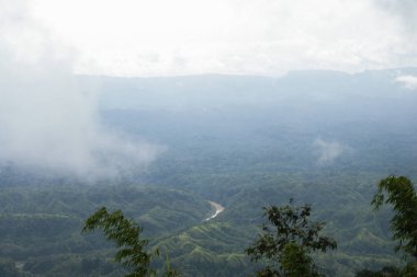 Bandarban, Bangladeş 'teki bir nehir akışının üst hava manzarası. Sis bulutu ve yeşil tepe manzaralı güzel doğa manzarası. Bulutlu gökyüzü ve kırsal tepe orman fotoğrafçılığıyla dağ manzarası.