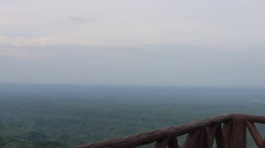 Hilly horizon footage on a top view spot at Bandarban, Bangladesh. Landscape mountain horizon view with cloudy sky and log fences. Aerial view of a mountain top resort. Hilly area 4K video.