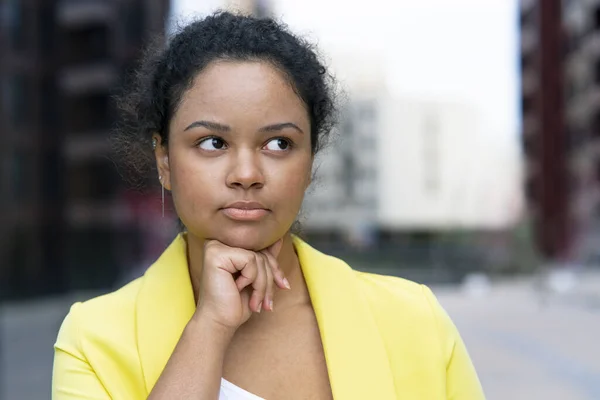 Portrait of a bored beautiful young black woman. Sad and serious Black girl, African American props up her face with her hand. mulatto Looking away.
