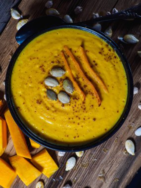 Kabak, havuç ve nohut kremalı çorba kırsal ahşap masada. Körili sonbahar balkabağı kremalı çorbası. Düz yatıyordu. Üst Manzara. Boşluğu kopyala.