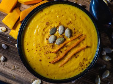 Kabak, havuç ve nohut kremalı çorba kırsal ahşap masada. Körili sonbahar balkabağı kremalı çorbası. Düz yatıyordu. Üst Manzara. Boşluğu kopyala.