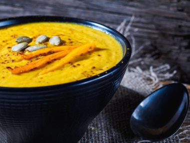 Kabak, havuç ve nohut kremalı çorba kırsal ahşap masada. Körili sonbahar balkabağı kremalı çorbası .
