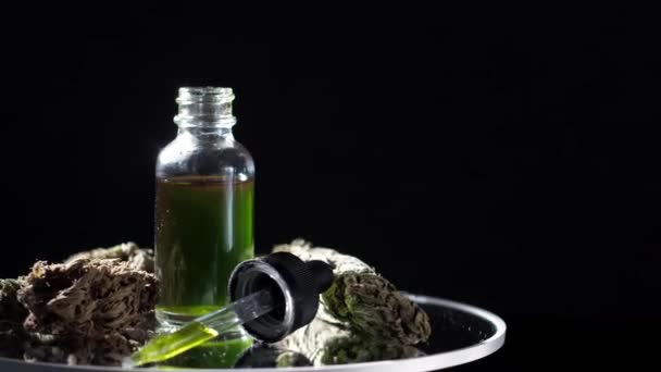 在干枯的大麻芽和医用大麻旁边 有一小瓶大麻精华素Cbd 黑暗的背景在镜子桌子上纺纱 — 图库视频影像