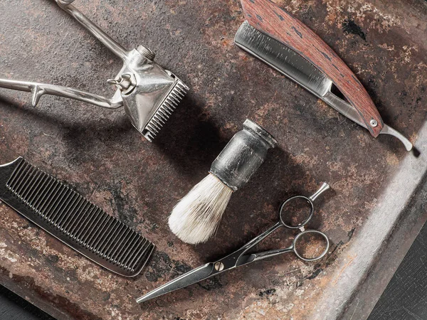 vintage barber tools dangerous razor hairdressing scissors old manual clipper comb shaving brush. on a rusty surface. flat lay top view