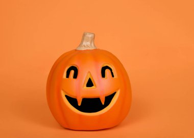 Turuncu arkaplanda fotokopi alanı olan turuncu balkabağı kabağı feneri.