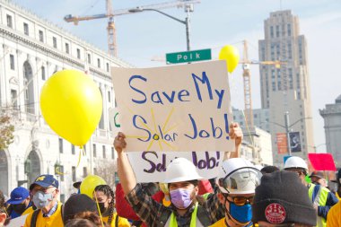San Francisco, CA - 13 Ocak 2022: Kaliforniya 'da güneş enerjisinden tasarruf etmek için düzenlenen mitingde kimliği belirsiz katılımcılar. Tabela tutuyor, protesto için devlet binasına yürüyor..