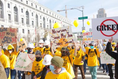 San Francisco, CA - 13 Ocak 2022: Kaliforniya 'da güneş enerjisinden tasarruf etmek için düzenlenen mitingde kimliği belirsiz katılımcılar. Tabela tutuyor, protesto için devlet binasına yürüyor..