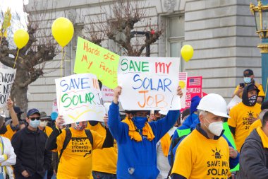 San Francisco, CA - 13 Ocak 2022: Kaliforniya 'da güneş enerjisinden tasarruf etmek için düzenlenen mitingde kimliği belirsiz katılımcılar. Tabela tutuyor, protesto için devlet binasına yürüyor..
