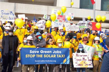 San Francisco, CA - 13 Ocak 2022: Kaliforniya 'da güneş enerjisinden tasarruf etmek için düzenlenen mitingde kimliği belirsiz katılımcılar. Tabela tutuyor, protesto için devlet binasına yürüyor..