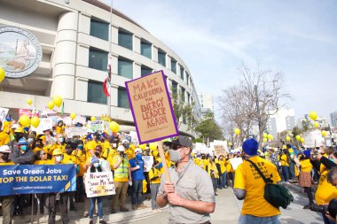 San Francisco, CA - 13 Ocak 2022: Kaliforniya 'da güneş enerjisinden tasarruf etmek için düzenlenen mitingde kimliği belirsiz katılımcılar. Tabela tutuyor, protesto için devlet binasına yürüyor..