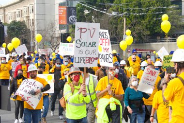 San Francisco, CA - 13 Ocak 2022: Kaliforniya 'da güneş enerjisinden tasarruf etmek için düzenlenen mitingde kimliği belirsiz katılımcılar. Tabela tutuyor, protesto için devlet binasına yürüyor..
