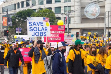 San Francisco, CA - 13 Ocak 2022: Kaliforniya 'da güneş enerjisinden tasarruf etmek için düzenlenen mitingde kimliği belirsiz katılımcılar. Tabela tutuyor, protesto için devlet binasına yürüyor..