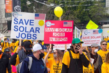 San Francisco, CA - 13 Ocak 2022: Kaliforniya 'da güneş enerjisinden tasarruf etmek için düzenlenen mitingde kimliği belirsiz katılımcılar. Tabela tutuyor, protesto için devlet binasına yürüyor..