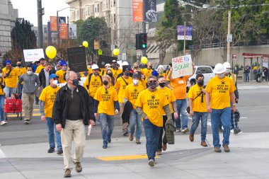 San Francisco, CA - 13 Ocak 2022: Kaliforniya 'da güneş enerjisinden tasarruf etmek için düzenlenen mitingde kimliği belirsiz katılımcılar. Tabela tutuyor, protesto için devlet binasına yürüyor..