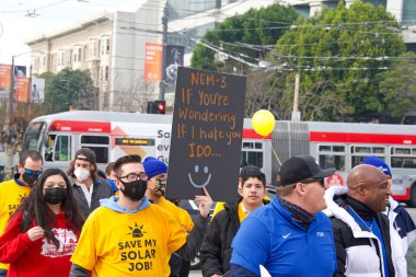 San Francisco, CA - 13 Ocak 2022: Kaliforniya 'da güneş enerjisinden tasarruf etmek için düzenlenen mitingde kimliği belirsiz katılımcılar. Tabela tutuyor, protesto için devlet binasına yürüyor..