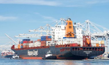 Oakland, CA - 01 Mart 2022 Hapag-Lloyd kargo gemisi London Express 'e Oakland Limanı' nda yardım eden römorkör.