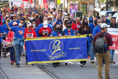 San Francisco, CA - 1 Mayıs 2022: Uluslararası İşçi Bayramı olarak da bilinen Pazar Caddesi 'nde yürüyüş yapan kimliği belirsiz katılımcılar. 
