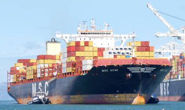 Oakland, CA - 9 Mayıs 2022: Kargo gemisi MSC AVNI 'nin Oakland Limanı' na manevra yapmasına yardımcı olan birden fazla römorkör.