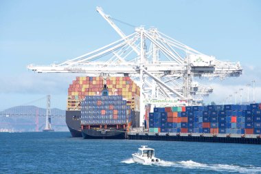 Oakland, CA - 7 Mayıs 2022: Oakland Limanı 'na yüklenen çok sayıda kargo gemisi, nakledilmeyi bekleyen binlerce konteynır.