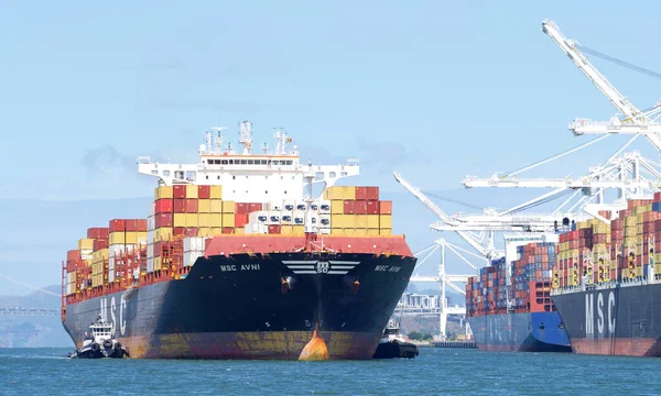 Oakland, CA - 9 Mayıs 2022: ABD 'nin en işlek beşinci limanı olan Oakland Limanı' na manevra yapmak için Kargo Gemisi MSC AVNI 'ye yardım eden birden fazla römorkör