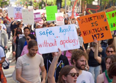 San Francisco, CA - 14 Mayıs 2022: Kimliği belirsiz katılımcılar, ellerinde Üreme Adaleti ve Kadın Seçme Hakkı 'nı destekleyen tabelalar tutarak sokaklarda yürüyorlar. 