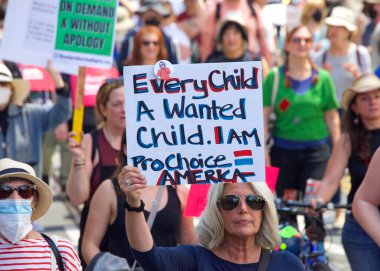 San Francisco, CA - 14 Mayıs 2022: Kimliği belirsiz katılımcılar, ellerinde Üreme Adaleti ve Kadın Seçme Hakkı 'nı destekleyen tabelalar tutarak sokaklarda yürüyorlar. 