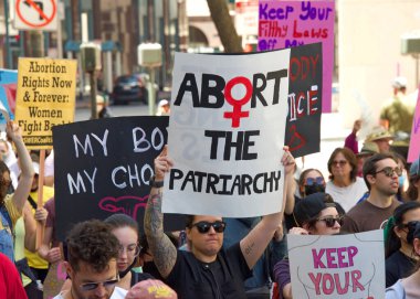 San Francisco, CA - May 14, 2022: Unidentified participants marching in the streets holding signs in support of Reproductive Justice and a Womans Right to Choose.