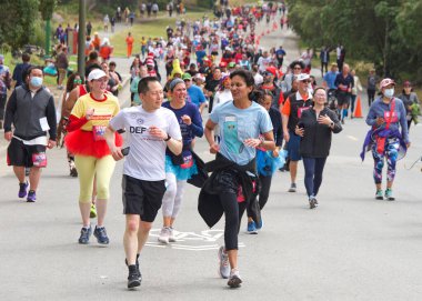 San Francisco, CA - 15 Mayıs 2022: Geleneksel Bay to Breakers yarışına katılanlar Golden Gate parkından geçiyor. Bay to Breakers, eğlenceli kostümler giyen birçok katılımcısıyla ünlüdür..