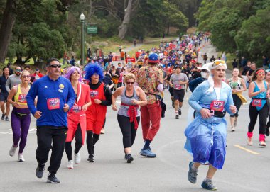 San Francisco, CA - 15 Mayıs 2022: Geleneksel Bay to Breakers yarışına katılanlar Golden Gate parkından geçiyor. Bay to Breakers, eğlenceli kostümler giyen birçok katılımcısıyla ünlüdür..