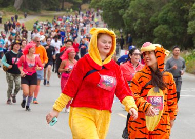 San Francisco, CA - 15 Mayıs 2022: Geleneksel Bay to Breakers yarışına katılanlar Golden Gate parkından geçiyor. Bay to Breakers, eğlenceli kostümler giyen birçok katılımcısıyla ünlüdür..