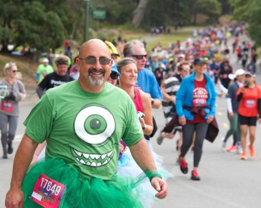 San Francisco, CA - 15 Mayıs 2022: Geleneksel Bay to Breakers yarışına katılanlar Golden Gate parkından geçiyor. Bay to Breakers, eğlenceli kostümler giyen birçok katılımcısıyla ünlüdür..