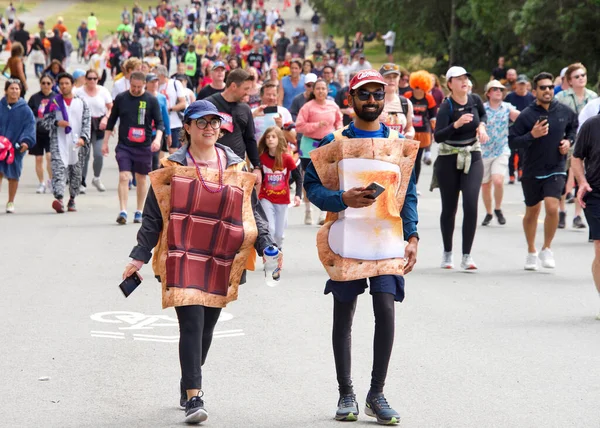 San Francisco, CA - 15 Mayıs 2022: Geleneksel Bay to Breakers yarışına katılanlar Golden Gate parkından geçiyor. Bay to Breakers, eğlenceli kostümler giyen birçok katılımcısıyla ünlüdür..