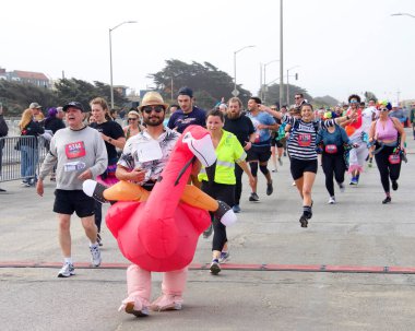 San Francisco, CA - 15 Mayıs 2022: Great Hwy 'deki yıllık Bay to Breakers yarışına katılanlar bitiş çizgisine geliyor. Bay to Breakers, eğlenceli kostümler giyen birçok katılımcısıyla ünlüdür..