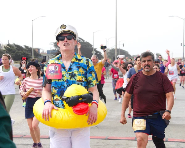 San Francisco, CA - 15 Mayıs 2022: Great Hwy 'deki yıllık Bay to Breakers yarışına katılanlar bitiş çizgisine geliyor. Bay to Breakers, eğlenceli kostümler giyen birçok katılımcısıyla ünlüdür..