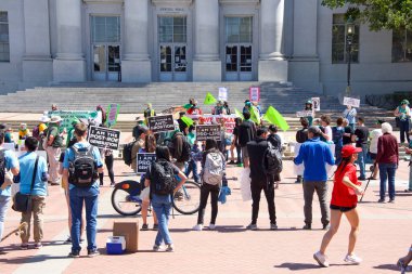 Berkeley, CA - 9 Nisan 2022: Kürtaj Hakları Mitingi 'nin kimliği belirsiz katılımcıları Sproul Plaza' nın diğer tarafında, iki grubun arasından geçen öğrenciler