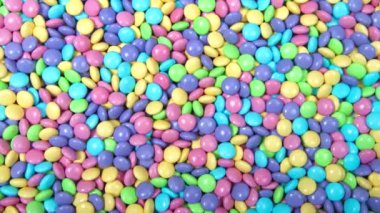 Pek çok pastel renkli çikolata kaplı şekerin arka planına yakınlaştırılmış HD videosu. Paskalya renkleri.